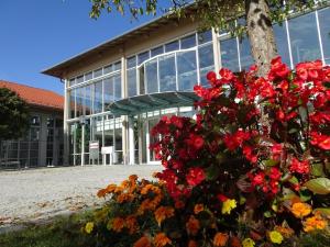 un edificio con un ramo de flores delante de él en Sportschule Oberhaching, en Oberhaching