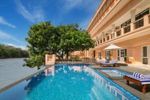 uma piscina em frente a um edifício em Pilibhit House, Haridwar – IHCL SeleQtions em Haridwar