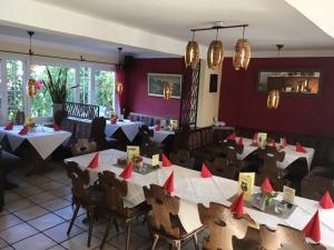um restaurante com mesas e cadeiras com guardanapos vermelhos em Zum weißen Ross em Nidda