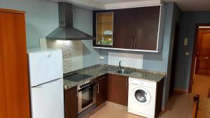 a kitchen with a refrigerator and a washing machine at Apartamento Loft III Select Real Caldas de Reis in Caldas de Reis
