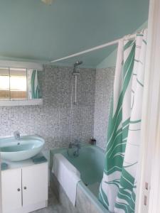 een badkamer met een bad en een wastafel bij La Tuilerie in Pindray
