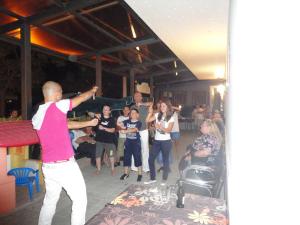 a group of people standing around a party with a man dancing at Hotel Al Ragno in Cesenatico
