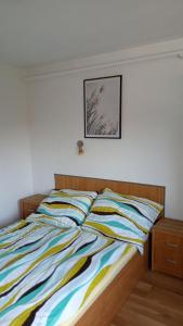 uma cama num quarto com uma fotografia na parede em Sifra 276 em Nová Lesná