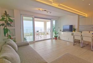 ein Wohnzimmer mit einem Sofa und eine Küche mit Meerblick in der Unterkunft The penthouse apartment in Beach house Ana in Duće