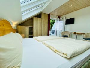 Un dormitorio con una gran cama blanca y una ventana en Landhotel Edersee, en Waldeck