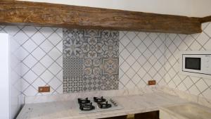 a kitchen with a stove and a tiled wall at LA CASONA DE MANUELA in San Benito de la Contienda