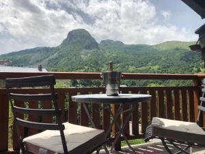 a table and chairs on a balcony with a view of mountains at Chalet Rose in Saint-Martin-de-Belleville
