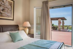 um quarto com uma cama e uma porta de vidro deslizante em Villa Sunset em Argostoli