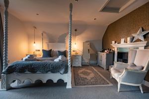 1 dormitorio con cama con dosel y silla en No33 HUNSTANTON BOUTIQUE ROOMS en Hunstanton