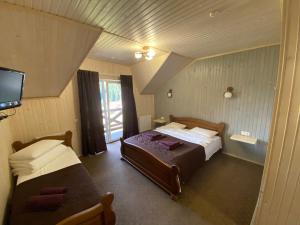 a bedroom with two beds and a flat screen tv at Villa Loiza in Bukovel