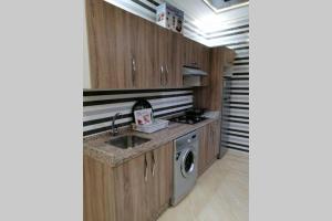 eine Küche mit einer Spüle und einer Waschmaschine in der Unterkunft Apprt 9 :) résidence Oulad Touimi in Martil