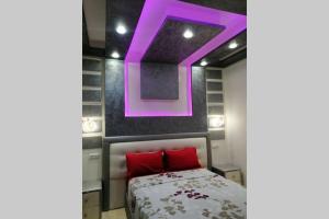 ein Schlafzimmer mit einem Bett mit einer violetten Decke in der Unterkunft Apprt 9 :) résidence Oulad Touimi in Martil