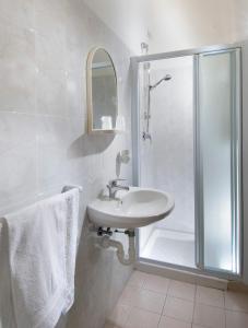 a white bathroom with a shower and a sink at HOTEL CASADEI in Rimini