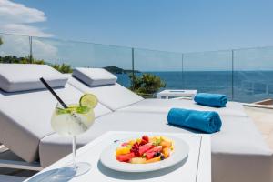 a table with a plate of fruit and a drink at Villa Orabelle in Dubrovnik