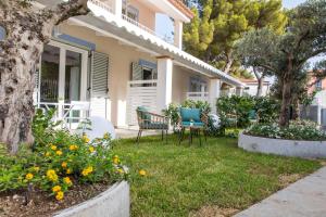 a house with chairs and flowers in the yard at 4essences Boutique Rooms in Maratea