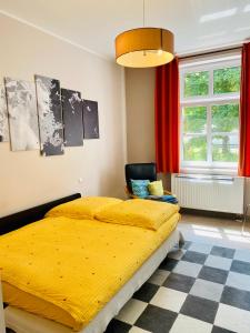 1 dormitorio con 1 cama amarilla y 1 silla en Villa FeWo mit separaten Schlafmöglichkeiten, zentral gelegen, en Chemnitz