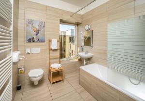 a bathroom with a tub and a toilet and a sink at Unesco Prague Apartments in Prague