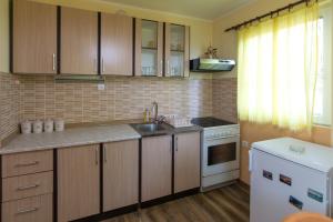 a kitchen with wooden cabinets and a sink and a stove at Zavicaj Zaovine2 in Zaovine +25 photos