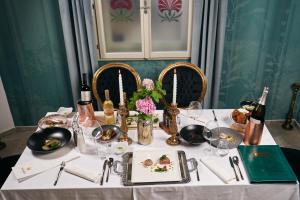 a table with a white table cloth and wine bottles at Dvorec Gregorčič in Smarjeske Toplice