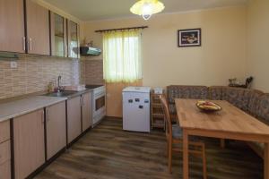 a kitchen with a wooden table and a kitchen with a dining room at Zavicaj Zaovine2 in Zaovine