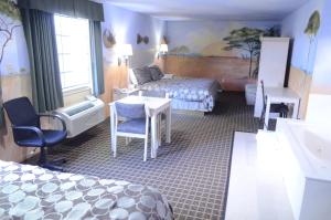 a hotel room with a bedroom with a bed and a desk at Scottish Inn and Suites NRG Park/Texas Medical Center - Houston in Houston