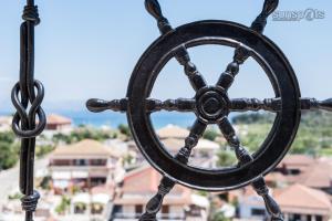 a wheel hanging from a chain on a balcony at Villa Konstantina in Petrití