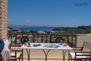 a table on a balcony with a view of the water at Villa Konstantina in Petrití