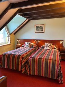
A bed or beds in a room at The Steadings, at The Grouse & Trout
