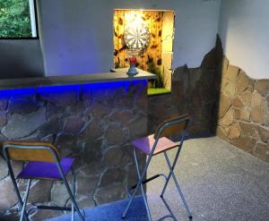 a bar with two chairs and a stone wall at Pontyhalász Vendégház in Tiszabábolna