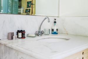 a kitchen counter with a sink and a mirror at Athenian Yard Near Acropolis in Athens +18 photos