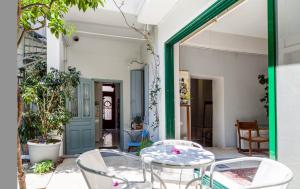 a patio with a table and chairs and a door at Athenian Yard Near Acropolis in Athens
