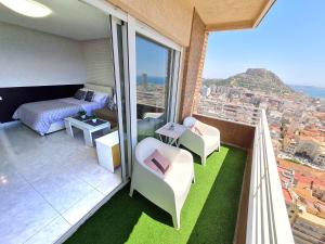 a bedroom with a bed and a balcony with a view at Mirador 22 in Alicante