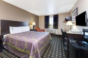 a hotel room with a bed and a desk at Super 8 by Wyndham Springfield East in Springfield