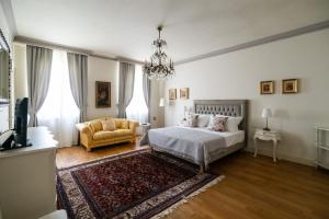 sypialnia z łóżkiem, kanapą i żyrandolem w obiekcie Villa San Pietro w mieście Desenzano del Garda +37 zdjęć