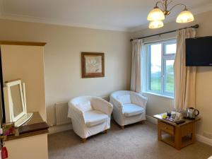 sala de estar con 2 sillas y ventana en Ardmore House en Clifden
