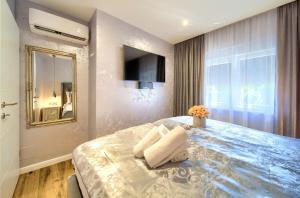 a bedroom with a large bed with towels on it at Luxury Apartments JF in Rab