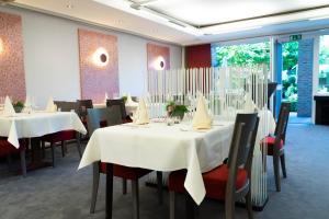 a restaurant with tables and chairs with white table cloth at Hotel Restaurant Esser in Wegberg