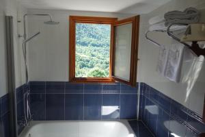 a bathroom with a bath tub and a window at Hotel Abetos in Torla-Ordesa