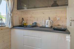 a kitchen with white cabinets and a counter top at Domki Portowe in Władysławowo