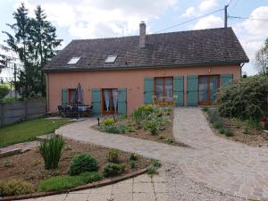 una pequeña casa con un jardín frente a ella en Maison d'Othe, en Saint-Mards-en-Othe