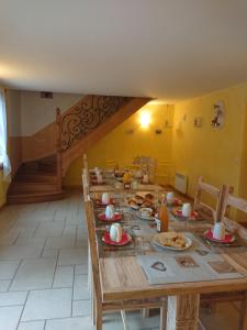una larga mesa de madera con platos de comida. en Maison d'Othe, en Saint-Mards-en-Othe