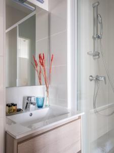 a bathroom with a white sink and a shower at Hôtel La Tour de Nesle La Rochelle Vieux Port in La Rochelle