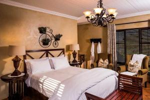 a bedroom with a large bed and a chandelier at Opikopi Guest House in Pretoria