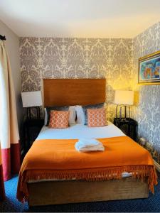 a bedroom with a large bed with an orange blanket at Telford Madeley Court Hotel in Telford