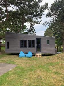 a tiny house sitting on top of a field at Tiny House by Lieblingsplatz in Sankt Peter-Ording