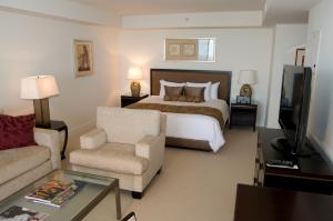 a bedroom with a bed and a couch and a tv at Jet Luxury Private Residences in Waikiki in Honolulu