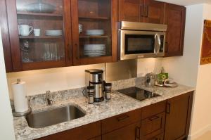 a kitchen with a sink and a microwave at Jet Luxury Private Residences in Waikiki in Honolulu