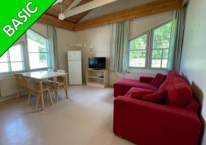 uma sala de estar com um sofá vermelho e uma mesa em Camping Nilimella em Sodankylä