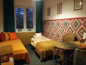 Cette chambre comprend 2 lits, une table et des fenêtres. dans l'établissement Animrumru, à Varsovie