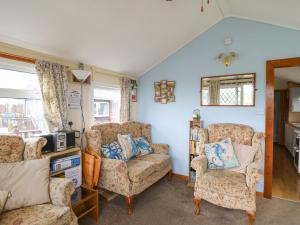 a living room with a couch and two chairs at Chalet 18 Smarty's View in Aberystwyth
